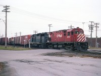 CP 4204 and C&O 3570, an eastbound freight; slows to a temporary stop at the station in Woodstock.  Just for a few moments the Ingersoll Ave crossing is fouled before the train moves on. This is nearly 40 years ago; today this same location is well protected with flashing lights and barriers. Track configuration has changed a lot as well.
