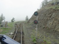 A cool misty morning on the "mountain", Kelly Lake hill. This is the south switch at Moran siding on the BC Rail Lillooet subdivision. We are heading north on the Rocky Mountaineer "Fraser Discovery". The signal governs the south switch "locally-controlled self-restoring dual control switch", also the north switch is signaled and self-restoring dual control switch. These switches were installed on several sidings on heavy grades and would restore the switches to "normal" after a train clears in the siding. This helped prevent trains having to stop and restore switches on the grade.