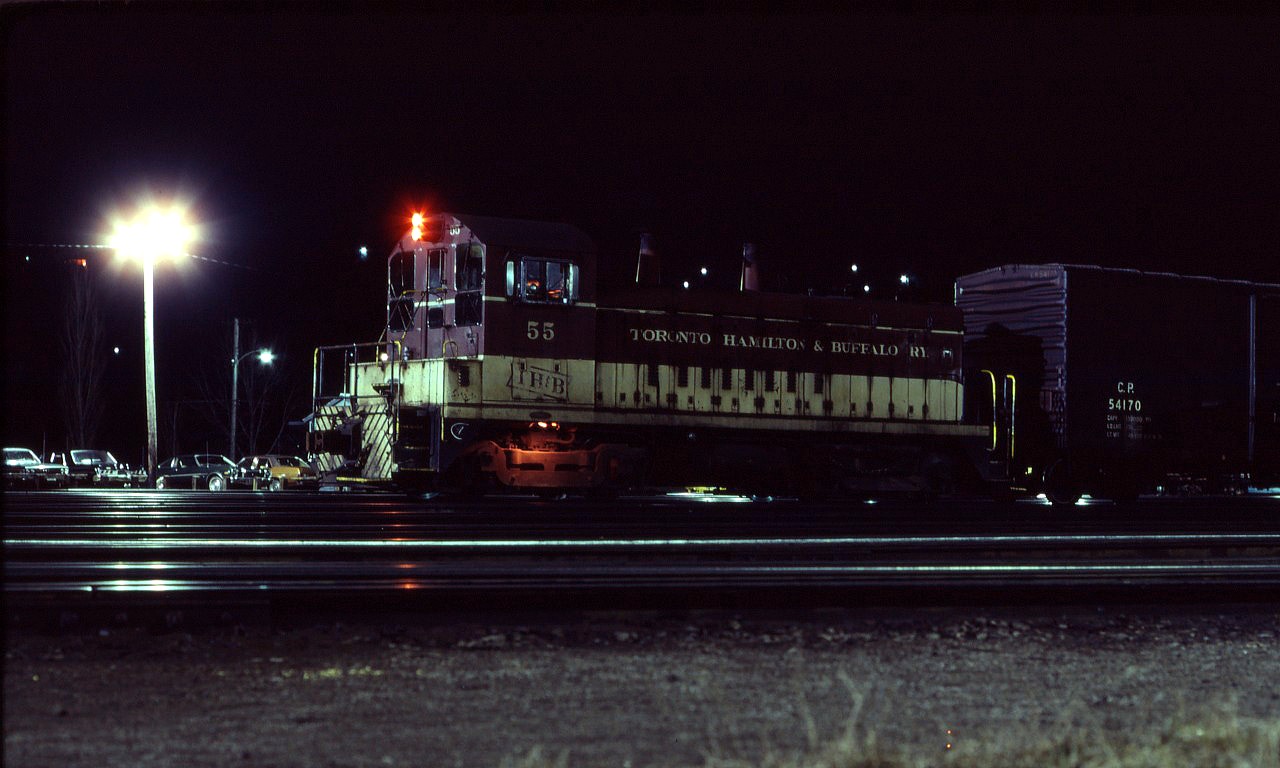 TH&B SW9 55 idles in front of the Aberdeen yard office prior to making its next switching move. Although Canadian Pacific took full ownership of the TH&B about a year ago, little has changed...however, over the next ten years, the TH&B will become increasingly reliant on parent company resources before being fully absorbed on January 1, 1987.