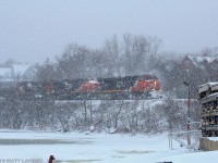 During a snow squall, CN train 406 rumbles along the Kennebacasis River, as they head by the Rothesay Yacht Club, approaching Saint John, New Brunswick. 