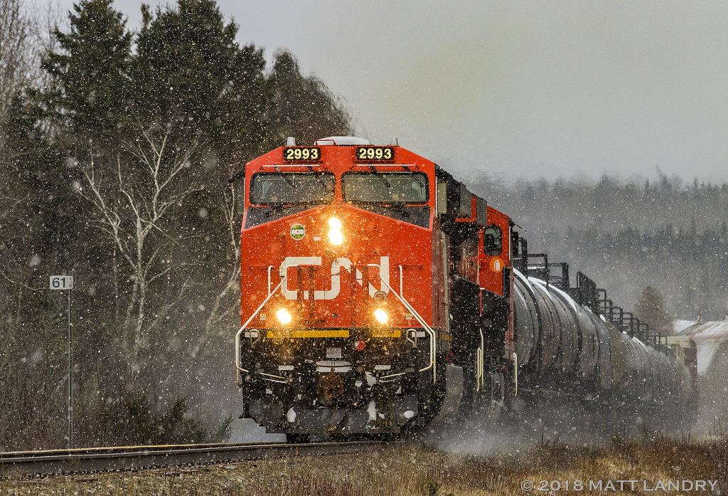During a small snowfall, CN 2993 leads westbound train 406, as they rumble through Passekeag, New Brunswick.