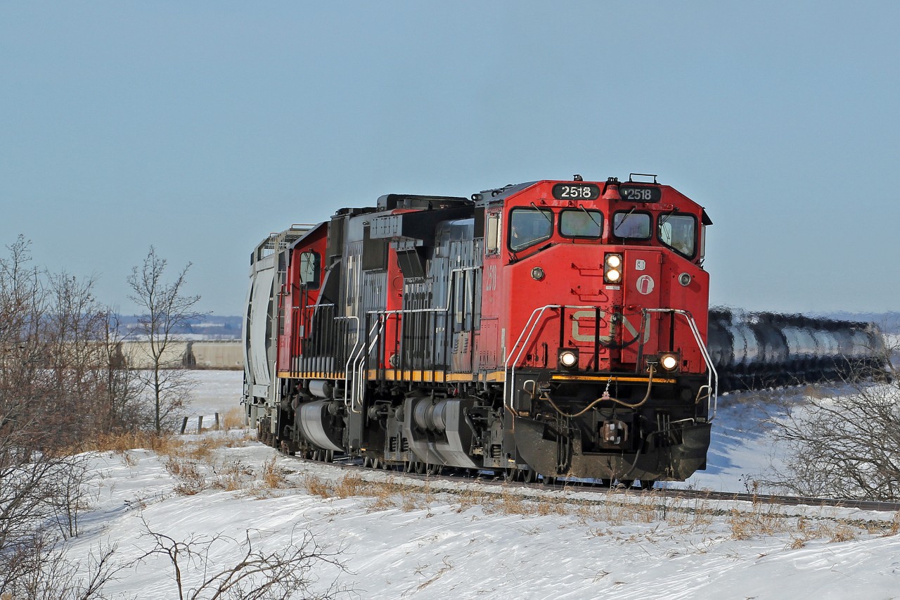 Dash 9-44CW CN 2518 and SD60 CN 5421 work hard up the hill east of Vegreville with a load oy hoppers and tank cars.