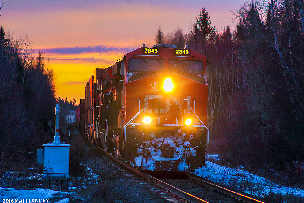During a colorful sky at sunrise, an AC leads Q121, shortly after departing Moncton, New Brunswick. Next up, the crew change at Edmundston, New Brunswick, about 225 miles away, by rail.