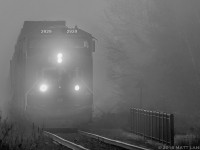 On a foggy Spring morning, CN 2929 leads train Q121, blasting through the fog at Berry Mills, New Brunswick. I don't do a great deal of black and white photos, but I thought maybe the mood of the photo lends itself to an attempt at something black and white. 