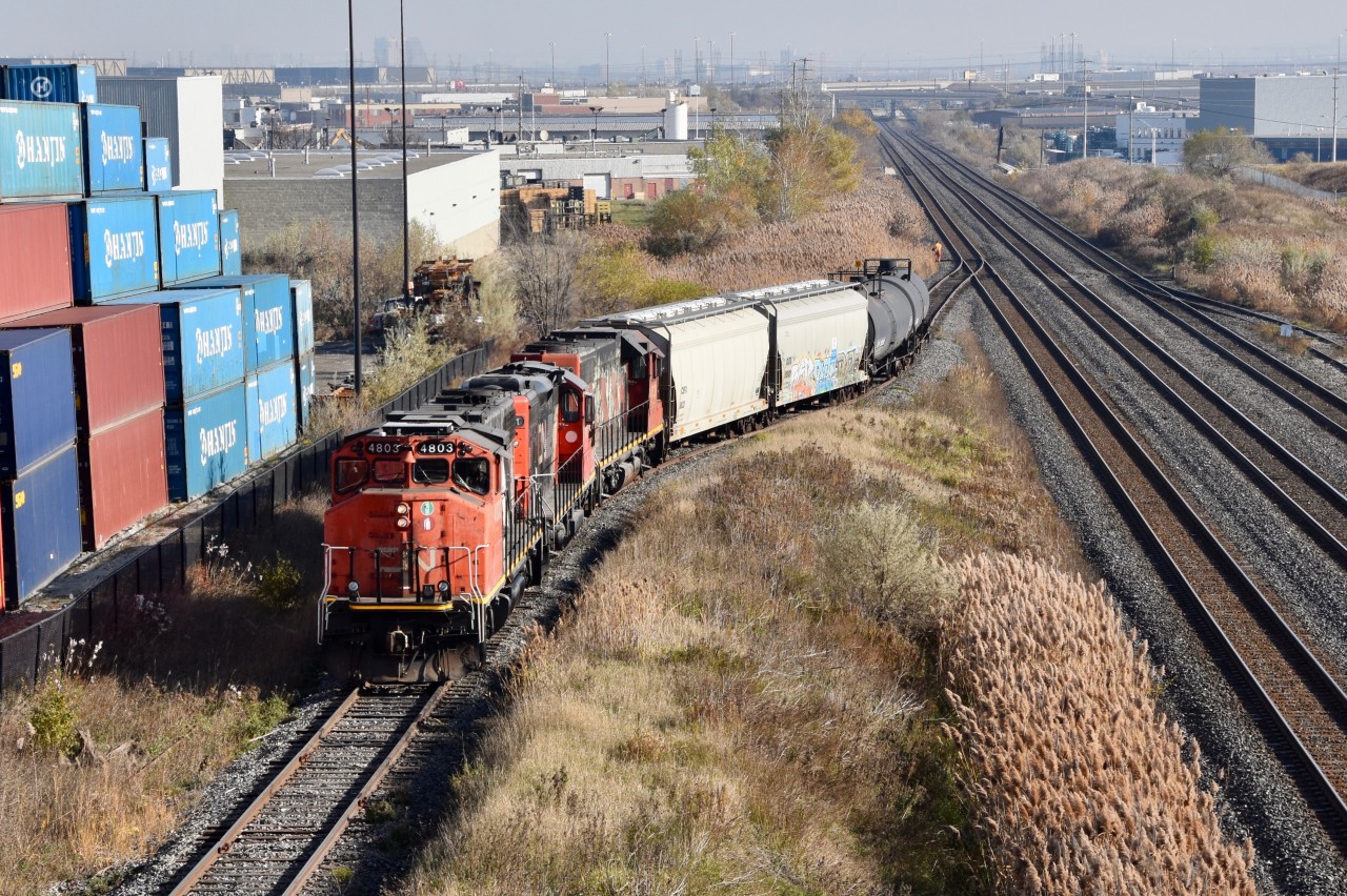 CN local (most likley 559) is seen switching on to the Consumer Glass Spur in Brampton. They have 2 hoppers to drop off at the Consumer Glass Plant which is at the end of this line and they will lift about 10 hoppers from the plant. The 2 tank cars will later on be dropped off at the Textile Rubber and Chemicals Plant on the Brampton Industrial Spur and 2 tank cars will be lifted from them as well.