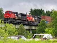 CN 8103 leads stack train Q121, heading over a small trestle shortly after passing through the town of Grand Falls, New Brunswick. 