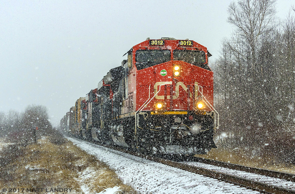 CN 3012 leads westbound train 406, as they approach Hampton, New Brunswick. There wasn't much going on, weather wise, for most of the day. About 15 minutes before the train arrived, it started to snow, and came down strong. About 20 minutes after the train went by, it cleared up. A mini snow squall I guess.