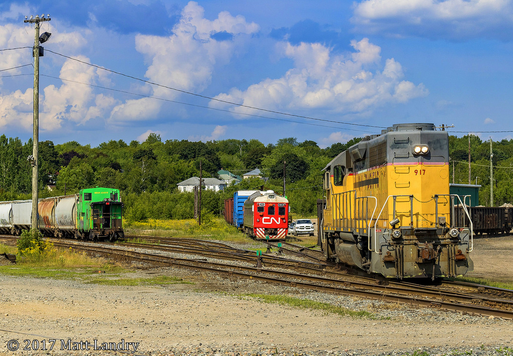 After CN 1501 parks at the shop track, NBSR 917 does a reverse movement back over to the shops, with an NBSR caboose sitting over on the left, for the next trip to St Stephen.