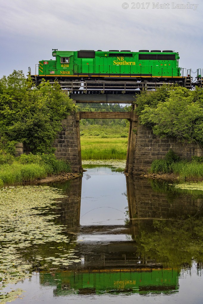 NBSR 6318 leads an NBSR eastbound 908 train, as they enter Saint John's yard limits, crossing over a small trestle as they arrive. I like how I was able to nab a good reflection of the leader.