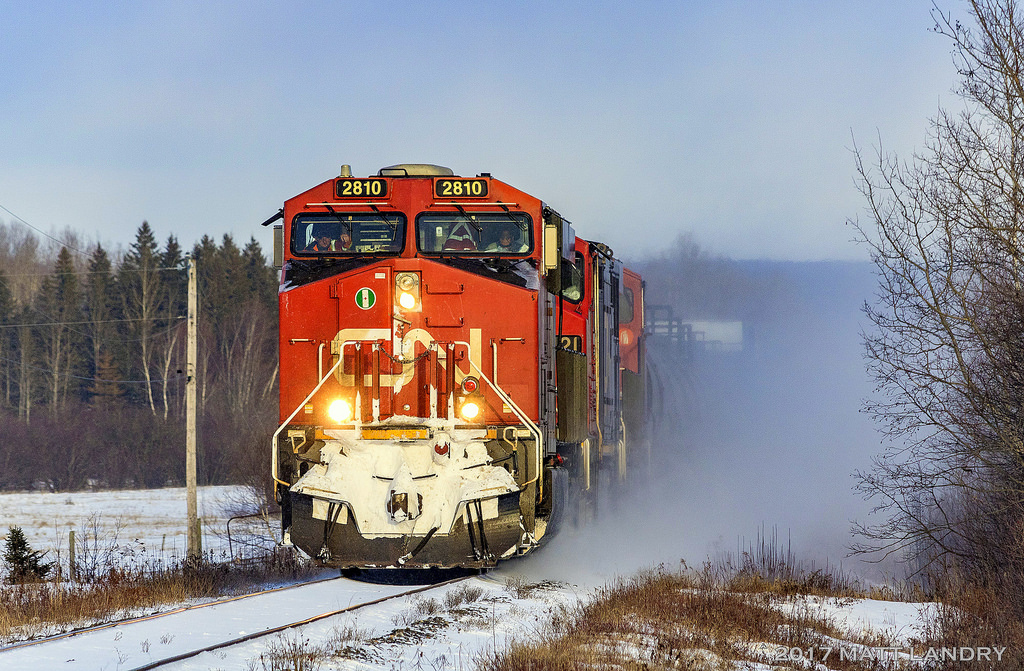 The day after a Christmas snowstorm, CN 2810 is westbound, bringing it's own snowstorm with them, as they approach the town of Sussex, New Brunswick.