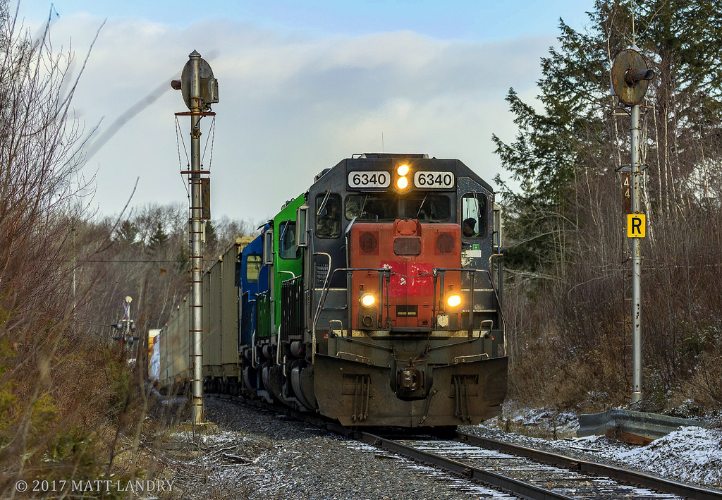 NBSR 6340 leads a New Brunswick Southern Railway westbound freight past an old set of signals at mile 4.4 of the Mattawamkeag Sub, shortly after a crew change at McAdam, New Brunswick.