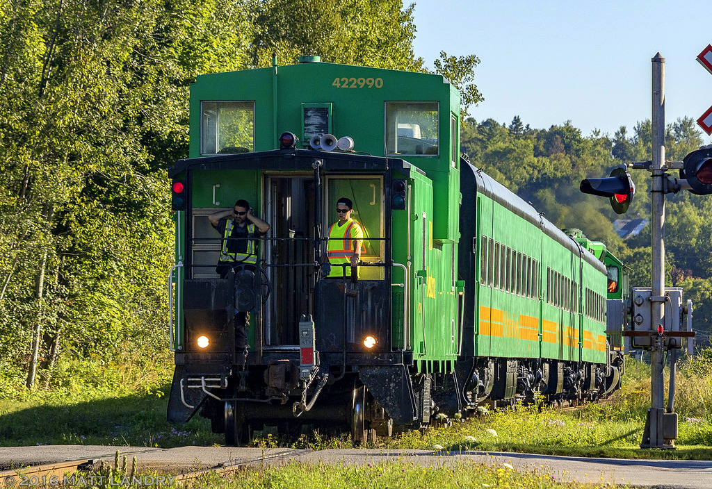 An NBSR passenger train does a reverse movement, as they head back down into Saint John, to pick up more passengers for the Dragon Boat festival at Renforth, New Brunswick. Because NBSR is running on CN tracks, a crew from CN and NBSR are required. Conductors from each railway are seen here manning the reverse movements. The NBSR conductor, on the left, isn't a fan of the horn on the caboose, being operated by the CN conductor. lol.