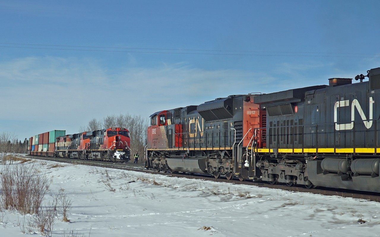 SD70M-2 CN 8912 and Dash 9-44CW CN 2616 enter the siding at Lindbrook with the crew member from CN 2816 off the locomotive ready to observe the run by.
