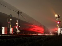 The intermediate searchlight signals still give off their distinctive glow at mile 34 of CP’s Galt subdivision, but change is on the horizon as new LED signals are all ready active just a few miles west at Guelph Junction, not to mention those that were installed as far west as Streetsville a couple of years ago, although not yet in use. Other changes not far off at this location is the relocation of Tremaine Road, including the elimination of the level crossing here replace further east by a new grade separation. It’s 3am as a pair of GE built AC 4400’s haul a short eastbound freight downgrade briefly disturbing the quite in the small village. A high fog cover is reflecting the bright lights from the town of Milton only a few miles to the east and adding some much needed light to this dark scene.