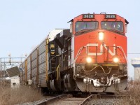 CN rack train 271 with NS 7203, a former UP SD90 trailing exits the plant at Milbase and storms past the glass lead. Milton's water tower can be seen in the distance.