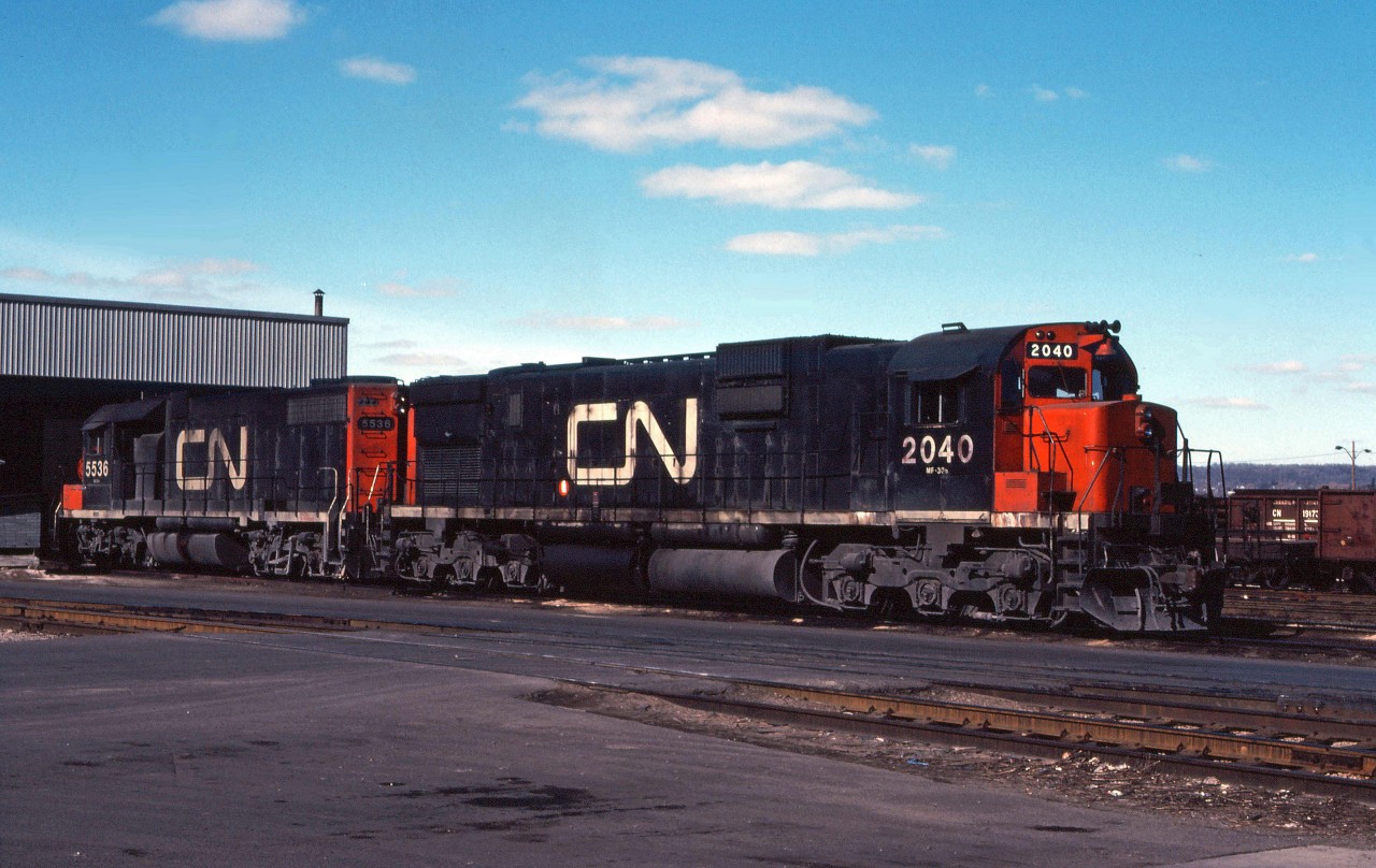 CN C630m 2040 and GP38-2 5536 rest in the sunshine outside the Stuart Street diesel shop on a bright spring day in 1980. While I don't have any records, these units likely arrived from Montreal on container/piggyback train 251 and will probably depart for Sarnia before the morning is over.