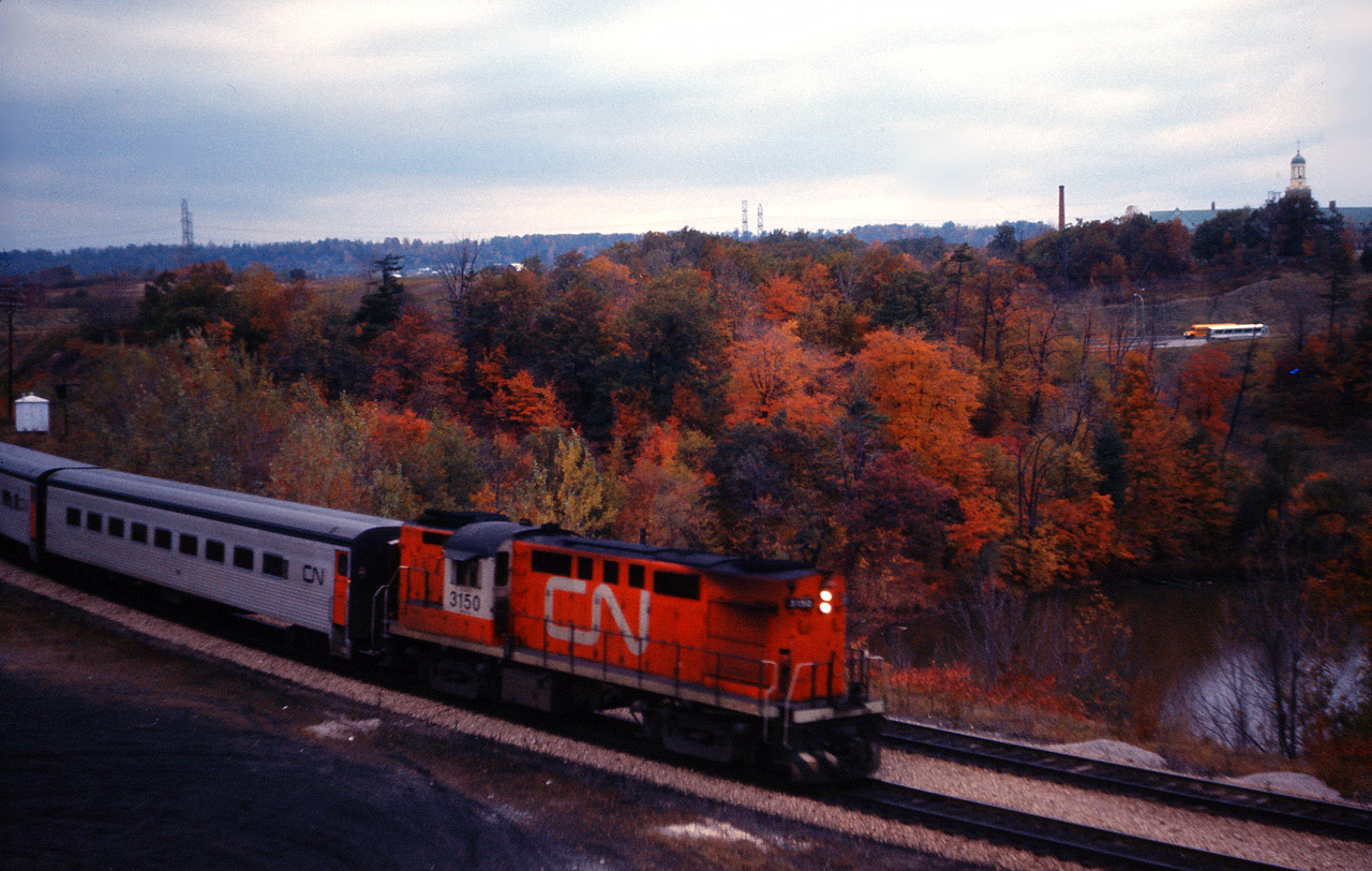 A very dull October day is brightened by fall foliage as a CN "Tempo" train passes through Hamilton West and Bayview on its way to Toronto.