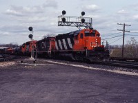 A CN westbound crosses from the South Track to the North Track at Bayview, heading for Hamilton and Niagara behind SD40 5068, GP9s 4526 and 4530, and SW1200RS 1259. In the background, another westbound is about to tackle the hill to Copetown and southwestern Ontario.