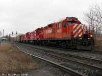 <b>1950's durability teams up with 2000's tech</b>: Canadian Pacific GP9u's 8239 and 8215 bracket nearly new NRE 3GS21B Genset locos 2100 and 2101, slamming Davenport Diamond eastbound on the North Toronto Sub with the usual transfer run #T56 (the Lambton-Agincourt Yard transfer run) and a sizable train on the drawbar. I was in the area enjoying an overcast and slightly rainy day and saw the train off in West Toronto Yard waiting to depart. I figured it was a pair or trio of SD40-2's, so expectations weren't really high. But sure enough, half an hour later the crossing gates go off and a pair of surprises show up trailing. This was shot from the old private crossing between the former Canadian General Electric Royce Works and Davenport Works plants that were under redevelopment at the time (and even though the crossing roadway was ripped up, the gates and signals were still perfectly functional).
<br><br>
CP was trying out a variety of different options to replace their aging fleet of 1950's 4-axle Geeps in the 2000's. First was the ill-fated "Green Goat" battery powered units made from rebuilt Geeps (they were a big flop). Next was this pair of "Genset" locomotives from National Railway Equipment that operated in local and transfer service (equipped with three small diesel engines instead of one larger one). While other roads seem to be happy with theirs, they failed to meet CP's performance expectations and were stored and returned to NRE with little fanfare. In the end, CP opted for the EMD GP20C-ECO program that saw hoards of their old GP9u's "rebuilt on paper" (meaning sent for scrap with truck frames, compressors, etc re-manufactured and used in the construction of new GP20C-ECO units built on new frames). A few lucky GP9 units including 8239 and 8215 managed to last long enough in local service to escape the trade-in program, and were instead declared surplus and sold off to shortlines, industrial operators and leasers.
<br><br>
But, the old gals did manage to outlast those newfangled Gensets.