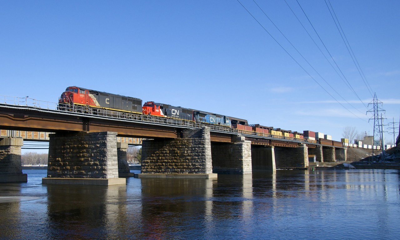 CN 2432, CN 5442 & IC 2459 lead a 574-axle long CN 149 over the Ottawa River as they leave Montreal on an unexpectedly sunny morning.