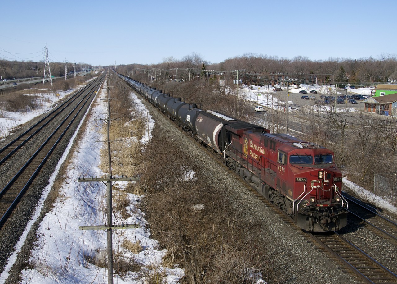 CP 8575 leads loaded ethanol train CP 650 through Beaconsfield. Pushing at the rear is NS 7295 and at left is the parallel CN Kingston Sub.