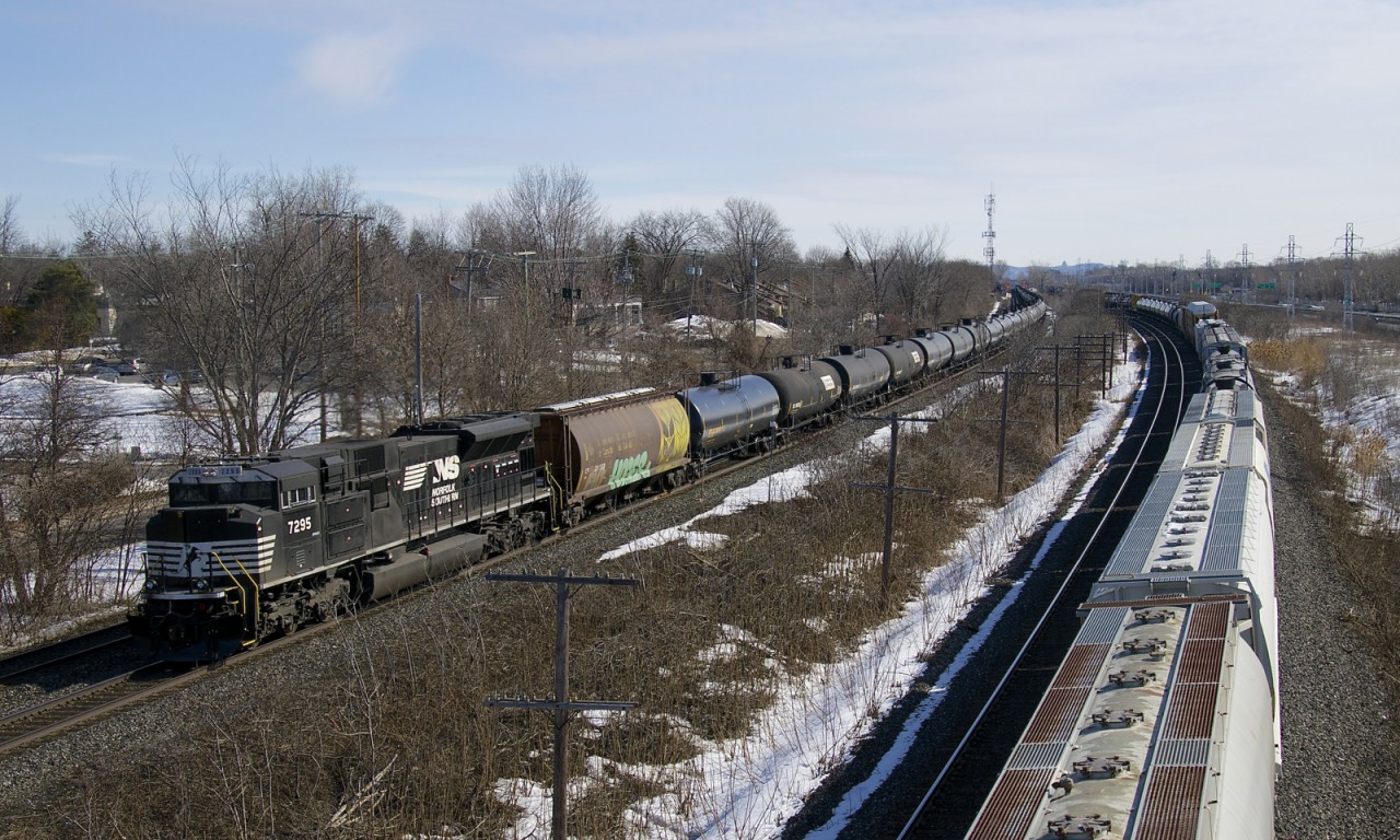 NS SD70ACu NS 7295 brings up the rear of loaded ethanol train CP 650 as it passes through Beaconsfield. Passing at right on the parallel CN Kingston Sub is CN X371.
