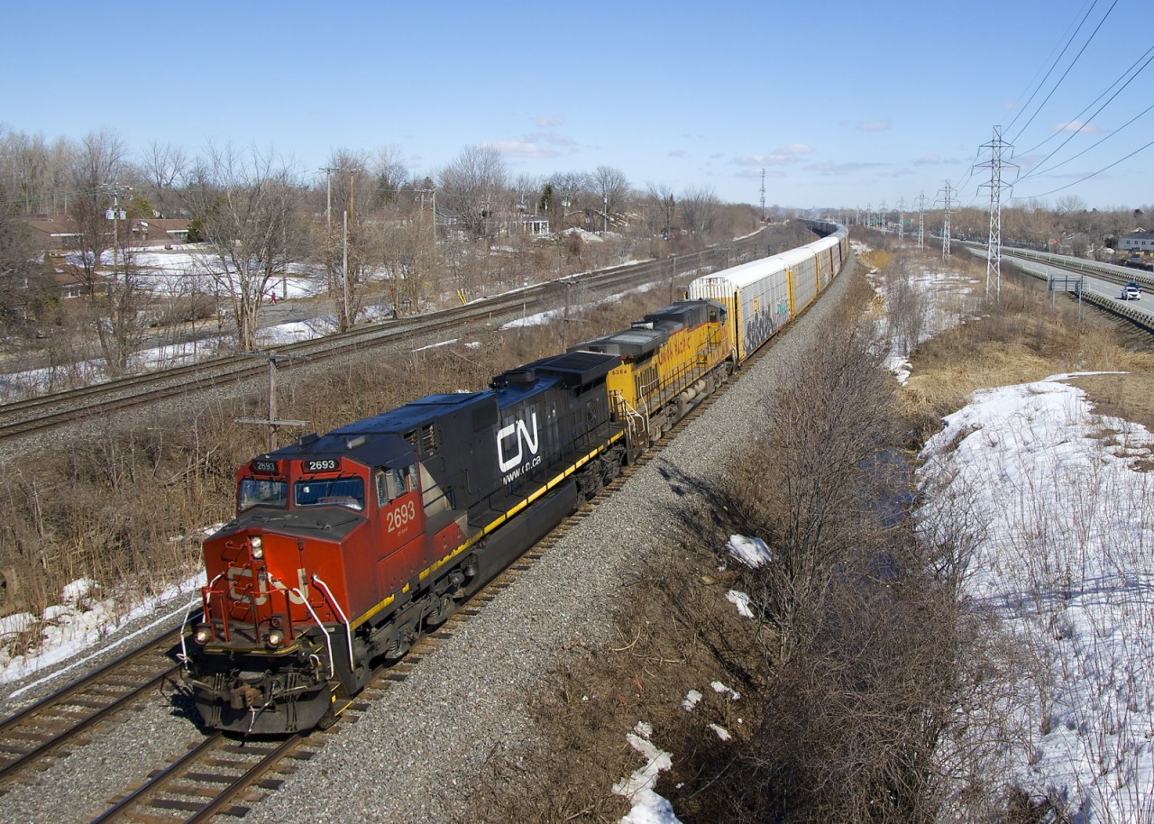CN 377 always runs with a consist of mixed freight, but today it consisted of 110 autoracks. Power is CN 2693 and ex-SP AC4400CW UP 6284 as it rounds a curve through Beaconsfield.