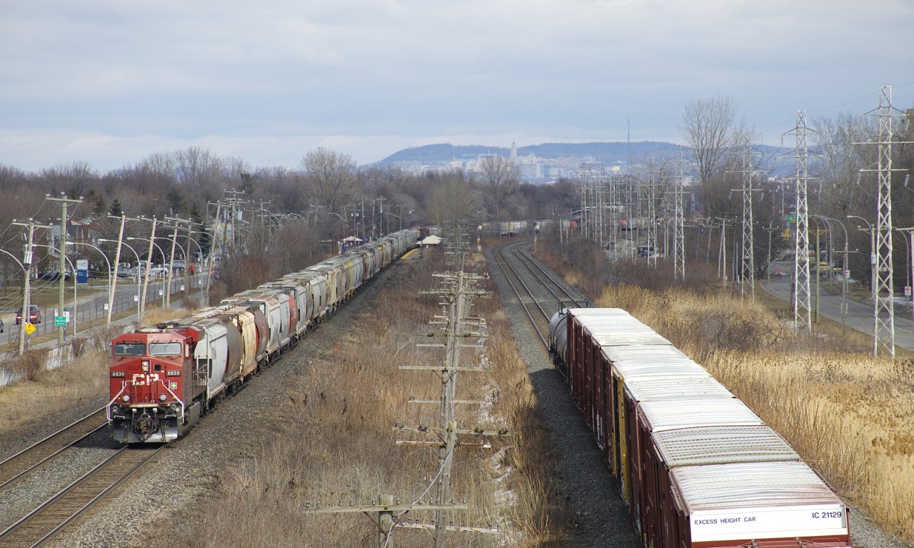 Grain train CP 332 is eastbound through Pointe-Claire, with CP 8830 bringing up the rear, passing just as the tail end of CN 327 passes on the parallel CN Kingston Sub.