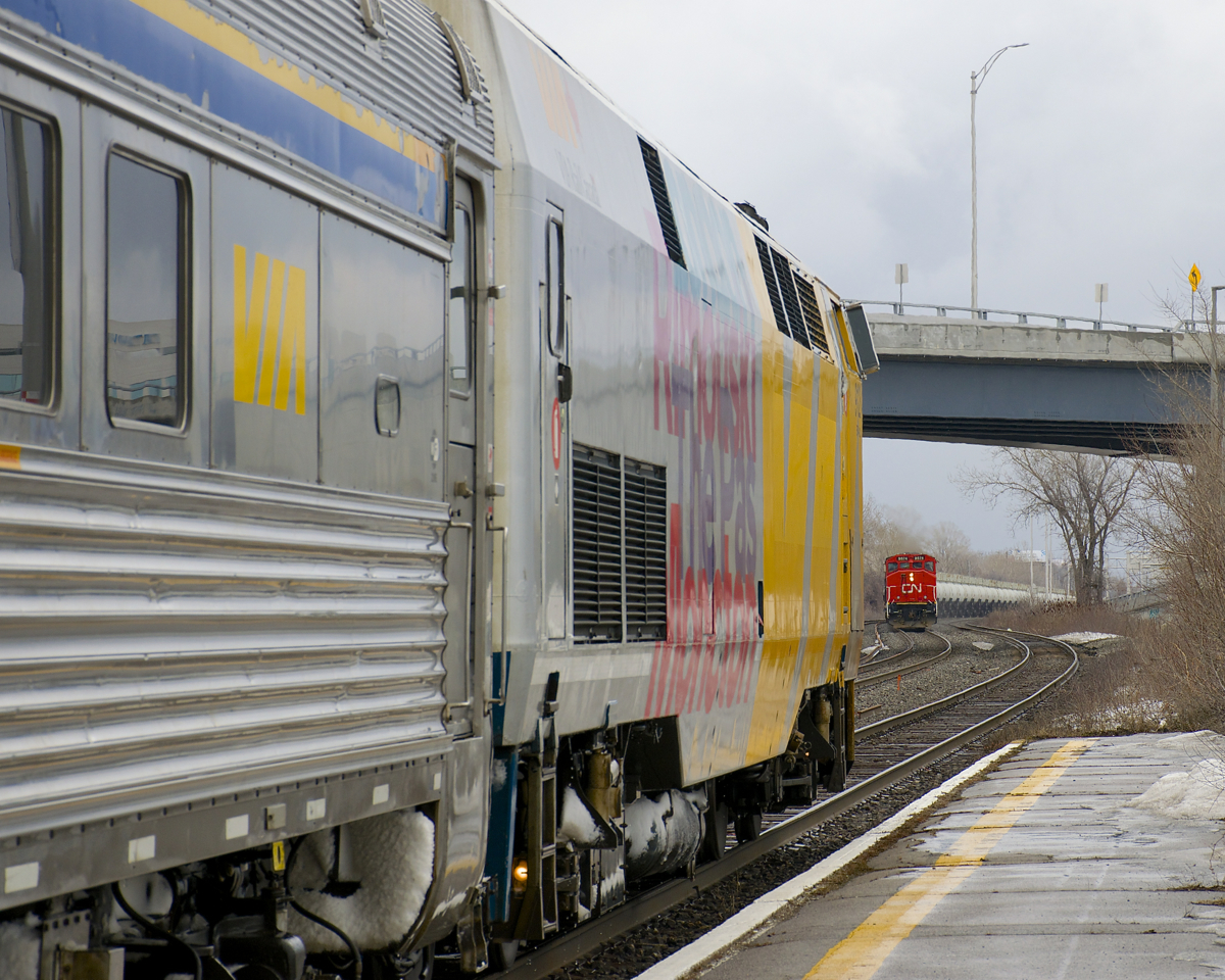 CN 585 is approaching Dorval Station as VIA 624 with VIA 912 leading departs after making its station stop.