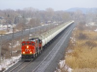 CN 9754 & CN 4729 lead CN 585 west through Pointe-Claire on a slightly snowy morning. The train has three strings of seventeen TankTrain cars, with fuel for an Ultramar facility in Maitland, Ontario.
