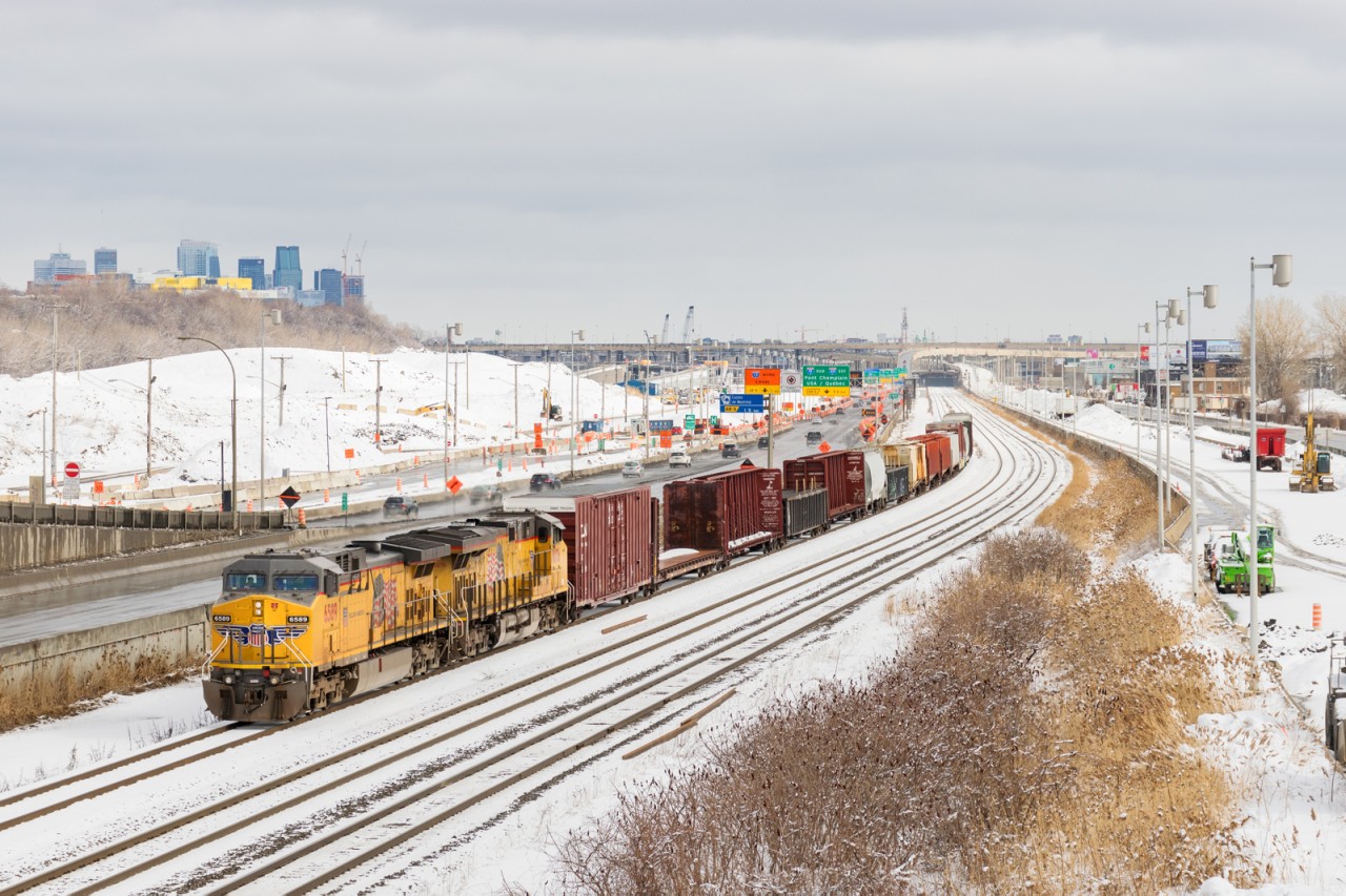 UP 6589 & UP 8076 lead a short 20-car CN 529 on CN's Montreal Sub, with the skyline of downtown Montreal in the background. This view will be gone by the end of the year, with CN's main line moving a bit further north (to the left in this picture).