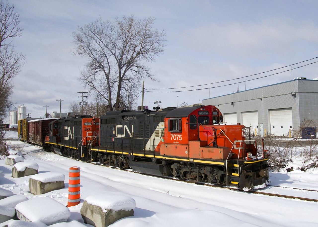 In a scene that see you less and less of, the Pointe St-Charles Switcher has GP9's CN 7075 & CN 7226 for power as it heads east on the Turcot Holding Spur with two empty boxcars picked up at the Kruger plant, one of two clients on this spur.