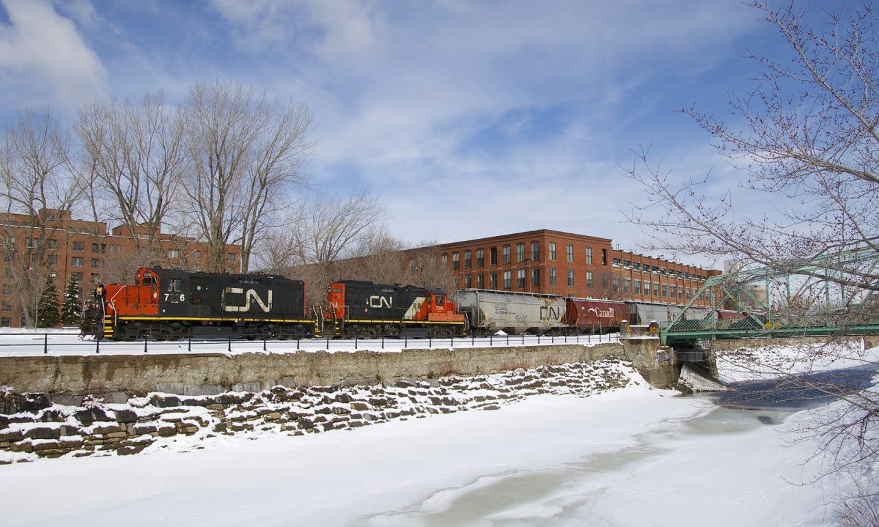 The Pointe St-Charles Switcher has GP9's CN 7226 & CN 7075 as it heads west along the frozen Lachine Canal after a crewmember flagged the Charlevoix crossing (by the bridge at right). It just left the Ardent Mill after picking up eight grain empties on CN's East Side Canal Bank Spur (the last client remaining on this line).