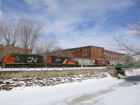 The Pointe St-Charles Switcher has GP9's CN 7226 & CN 7075 as it heads west along the frozen Lachine Canal after a crewmember flagged the Charlevoix crossing (by the bridge at right). It just left the Ardent Mill after picking up eight grain empties on CN's East Side Canal Bank Spur (the last client remaining on this line). 