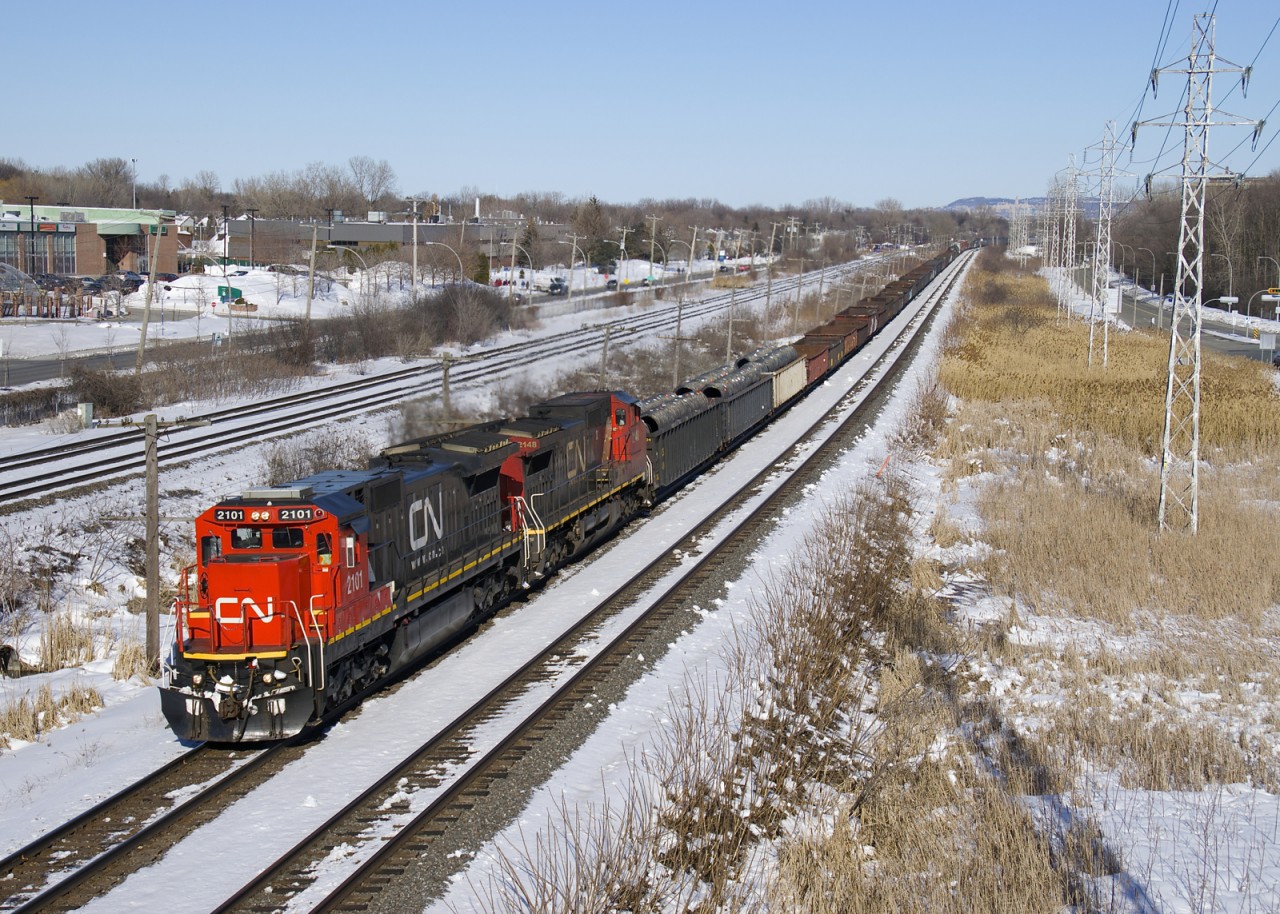 CN X321 with spotless CN 2101 and CN 2148 for power heads west on the north track of the Kingston Sub on a sunny but quite cold afternoon. At the head end are a long string of loaded gons, a hallmark of CN X321, which originates at Southwark Yard with overflow traffic on an as needed basis.