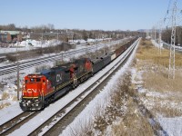 CN X321 with spotless CN 2101 and CN 2148 for power heads west on the north track of the Kingston Sub on a sunny but quite cold afternoon. At the head end are a long string of loaded gons, a hallmark of CN X321, which originates at Southwark Yard with overflow traffic on an as needed basis.