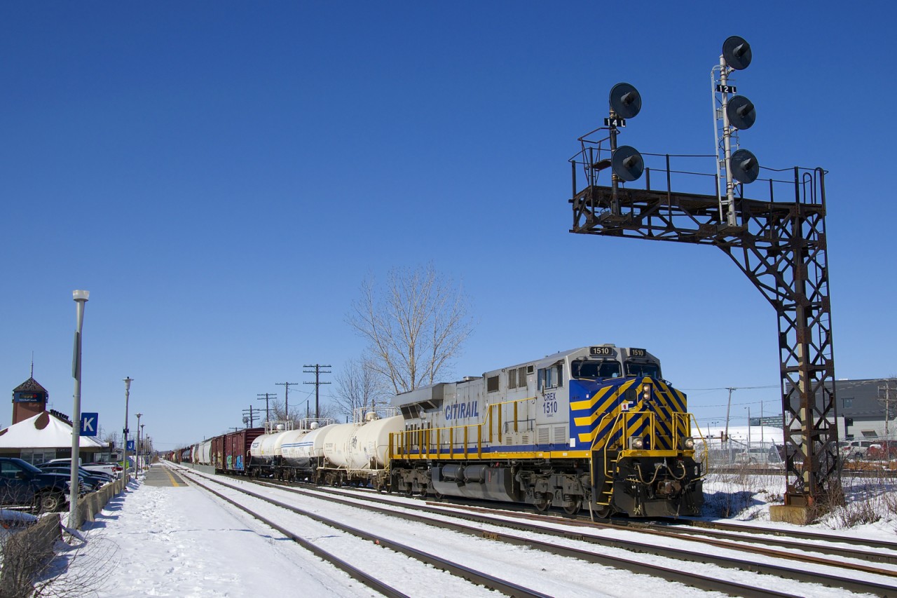 Leased unit CREX 1510 leads CN 368 as it passes under a signal gantry near Dorval Station as the train crosses from the north track to DX-1 track. Mid-train is CN 2903.