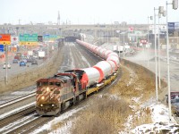 Windmill train CN L307 has 50 windmill towers spread over 75 cars as it approaches a crew change Turcot West with Dash8's BCOL 4611 & CN 2103 for power. This train will be handed off to the BNSF at Eola and are destined for Garden City, KS. At right work continues on dismantling the westbound lanes of autoroute 20.