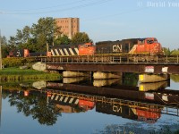 Mornings in Thunder Bay were very rewarding. CN's daily freight usually arrived around dawn and their trek across town to Port Arthur would have the sun positioned perfectly for photography. On this early August morning A436's power scoots across the glass-like McIntyre River with CN SD75i 5690-SD60F 5518-GP9 Slug 229-GP9RM 7268 with darn near a perfect reflection. 