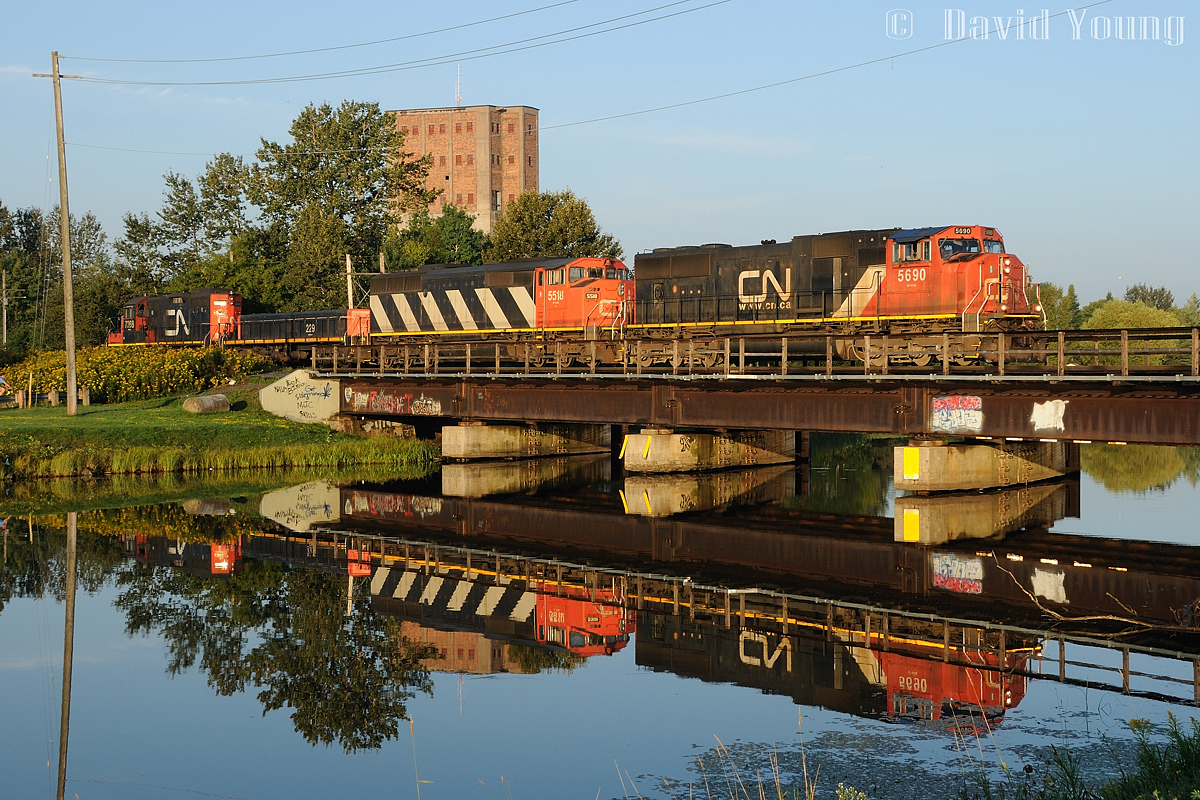 Mornings in Thunder Bay were very rewarding. CN's daily freight usually arrived around dawn and their trek across town to Port Arthur would have the sun positioned perfectly for photography. On this early August morning A436's power scoots across the glass-like McIntyre River with CN SD75i 5690-SD60F 5518-GP9 Slug 229-GP9RM 7268 with darn near a perfect reflection.