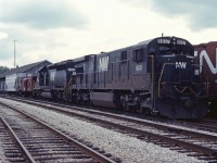 Two black Norfolk & Western units (C30-7 8037 and SD40-2 6203) sit outside the CN-NS "joint section" offices in St. Thomas in the fall of 1984.