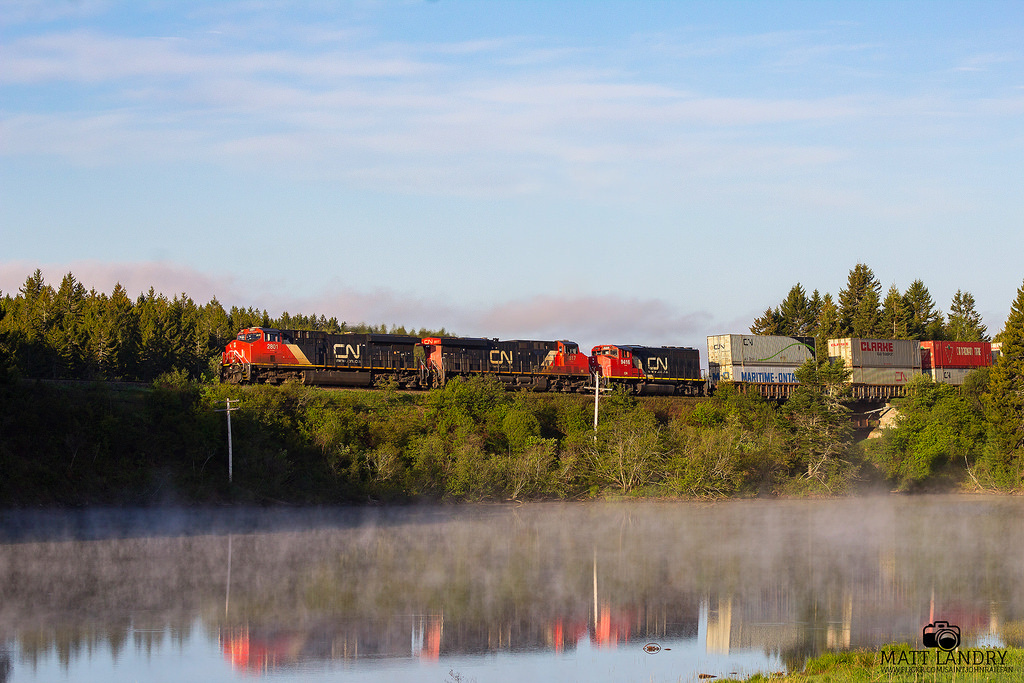 CN 2801 leads stack train Q120 as they rumble by Palmers Pond, at Dorchester, New Brunswick, at sunrise.