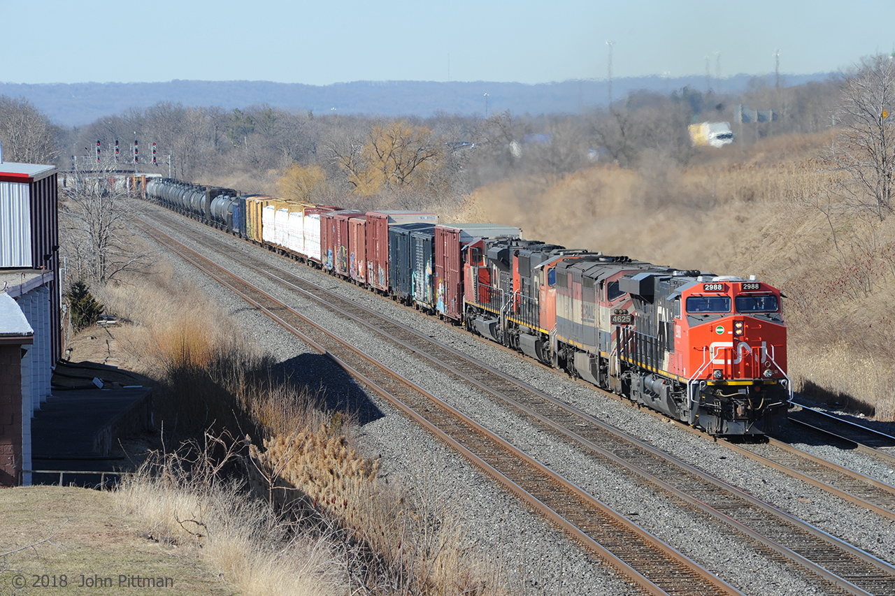 CN 2988 with BCOL 4625, CN 5633, CN 8868  leads train 422 uphill east on the Oakville Sub out of Hamilton toward Aldershot Yard in Burlington.  A couple of miles ahead the train will be cut, the back end tied down, and the front end backed into the yard at Aldershot East to drop and lift railcars. The signals at CN Snake where 422 crossed over to Track 1 can be seen about a mile back. Farthest track is the west yard lead.