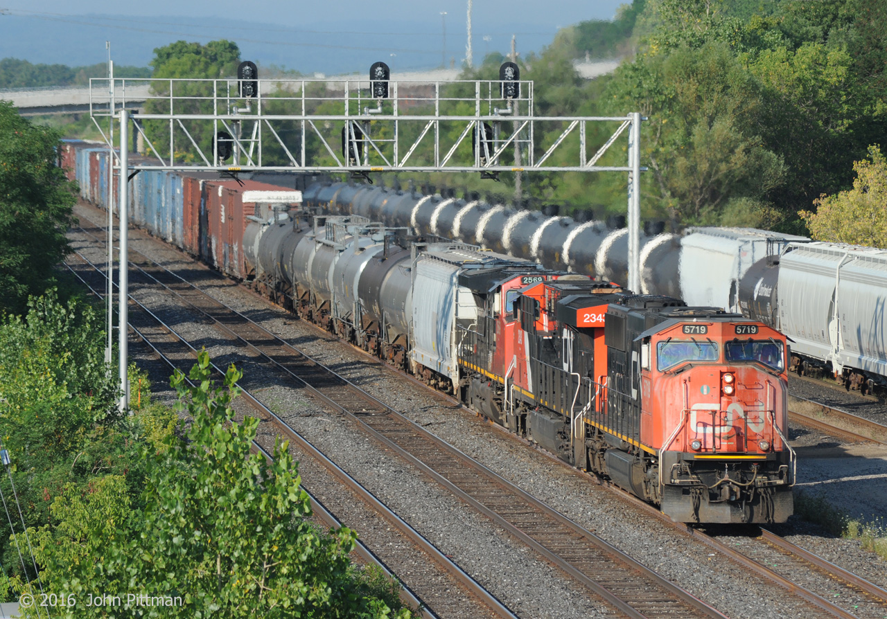 Twenty year old CN 5719 (SD75i) with CN 2343 (ES44dc) and CN2569 (C44-9w) leads train 422 under Oakville Sub signal 348T1, beside the west end of Aldershot yard.  Head end cars that 422 will drop off in the yard from Aldershot East include high-cube auto parts boxcars for the Ford Oakville Assembly Plant.