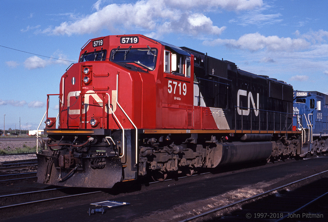 Seven month old SD75i CN 5719 is sitting in the sun outside the Diesel Shop at Symington yard in Winnipeg. 
Permission to photograph on CN property was granted, but that is unlikely to happen nowadays.

Twenty years later CN SD75 units continue to be regularly seen on CN freight trains in Ontario, with the original orange-red showing its age.