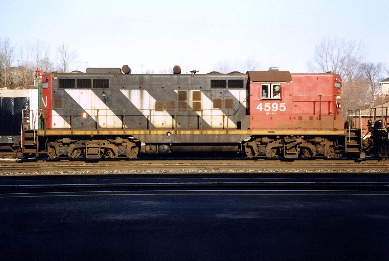 The CN steel train from Hamilton pulls in to Brantford yard with CN 4595 leading CN 4141 (out of frame).  With cabooses on both ends of the train, the locomotives will quickly run around the train and depart for the Hagersville Subdivision and ultimately the Stelco Steel mill in Nanticoke, ON.  Check out the 90's attire the conductor is wearing.  The date is an educated guess because I didn't label my prints in the first few years that I photographed trains.  CN 4595, the only high nose CN GP9 I ever photographed, was rebuilt in to GP9RM 7274 late 1993.  CN GP9RM 4141 on the other hand, was rebuild from GP9 4241 early 1991.  So this photo was taken in 1991 or 1992, and judging by the road grime on 4141 in another photo I took that day I'm going with 1992.  Yes the photo is grainy, but considering the camera and my inexperience I'm surprised the photo came out as good as it did.  You young railfans these days don't know how lucky you are to have fancy digital cameras to start off with!