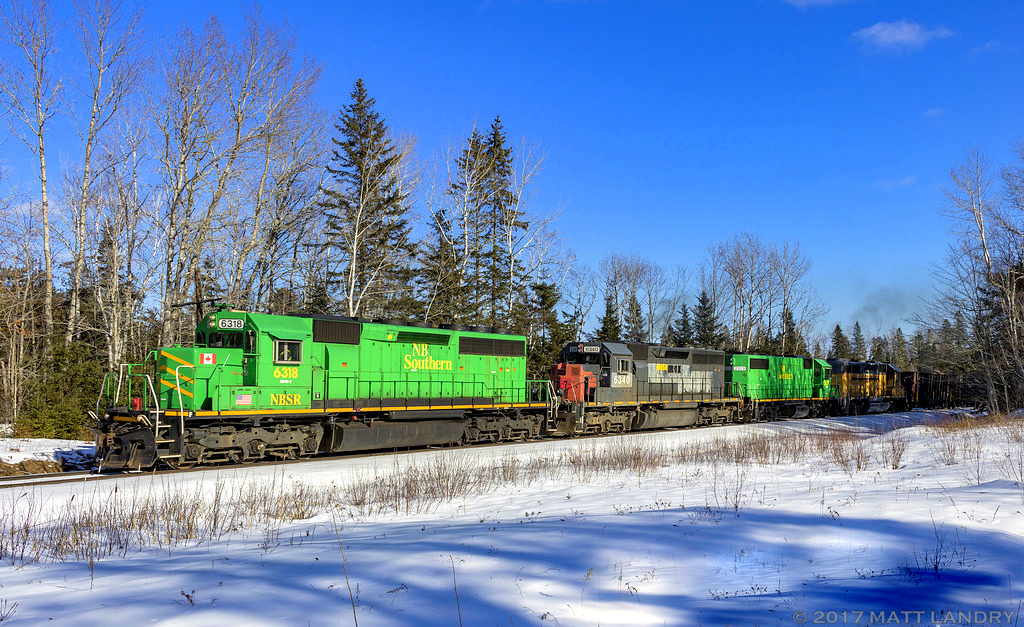 With a colorful lashup, NBSR 6318 is westbound, leading a New Brunswick Southern Railway freight at Vespra, New Brunswick.