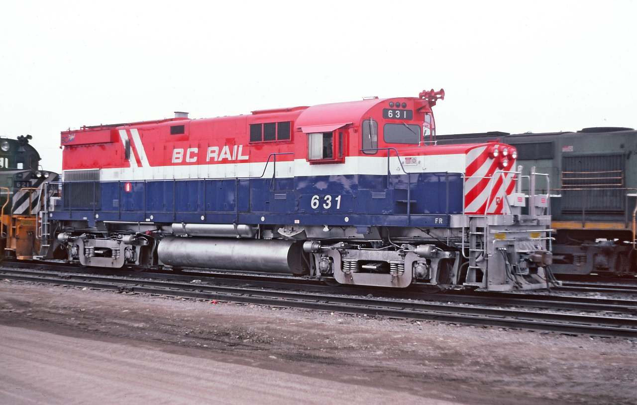 On the shop track at Prince George, a misty morning and perhaps some smog from the pulp mills. BCR 631 sporting fresh paint and a fancy headlight arrangement. Dual seal beam headlights as well as ditch lights. Also the unit has been adapted for operating a slug in yard service.