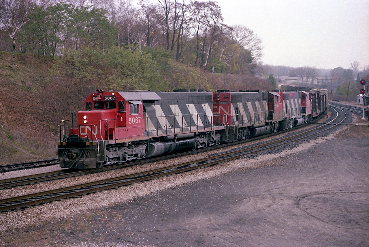 Nice combination of power, SD40 5067 leads GP38-2 5584 and 5574 around the curve at Bayview, running off the CN Oakville Sub westbound onto the Dundas on a dreary day many years ago. The lead unit eventually went to the New Brunswick East Coast, and the trailing units were renumbered in 1988 to 4784 and 4774 respectively.