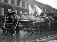 <b>Steam on a rainy day:</b> Canadian National 4-8-4 "Northern" 6167 waits along the wet platforms outside of Toronto's Union Station train shed, before heading out on an excursion in 1962.
